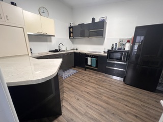 Renovated kitchen with gas cooktop, underbench oven, microwave and full-size family fridge