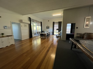 Timber floored living and dining area with pool table and large dining setting