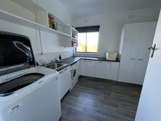 New laundry with washer, dryer, twin sinks and full-height storage