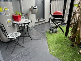 Enclosed courtyard with gas Weber BBQ and small outdoor setting